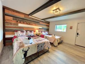 a bedroom with two beds and a wooden wall at Retreat on the Lake in Hiawassee