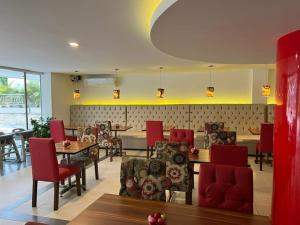 a dining room with red chairs and tables and tablesktop at Hotel Juan Maria in Tuluá