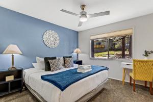 a bedroom with blue walls and a bed and a window at High Country Lodge in Flagstaff