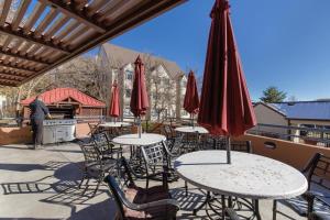 a group of tables and chairs with umbrellas on a patio at 1 Bedroom Apt - Gym - DTC Boston Commons in Greenwood Village
