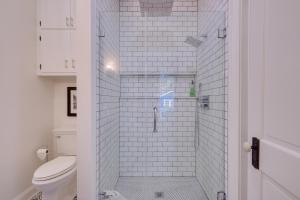 a white bathroom with a shower with a toilet at WFH Friendly Abode with Balcony in Columbus! in Columbus +32 photos
