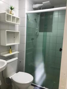 uma casa de banho com um WC e uma cabina de duche em vidro. em Ap. Espetacular. À 5 minutos da praia. em Aracaju