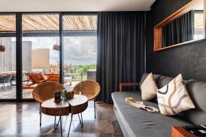 una sala de estar con un sofá y una mesa en Iik Tulum Luxury Penthouses by Spot Rentals, en Tulum
