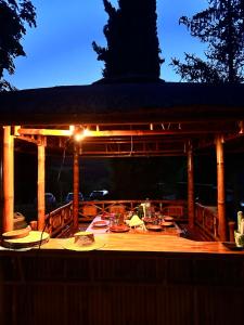 a wooden gazebo with a table and lights on it at Appartement à la ferme in Thoard