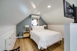 ein Schlafzimmer mit einem weißen Bett und einem Fenster in der Unterkunft Wolf Lake Vacation Rental with Fire Pit! in Jackson
