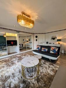 ein Wohnzimmer mit einem Sofa und einem Tisch in der Unterkunft FINN VILLAGE "Raspberry Cottage" Private Garden, 6-seater Hot Tub, Firepit & Pizza Stove in Glasgow