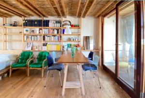a dining room with a wooden table and green chairs at San Liberale sul mare in Trapani