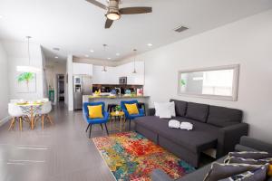 sala de estar con sofá negro y cocina en Peaceful Home in Serenity Disney area, en Orlando