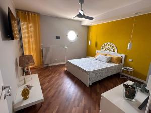 1 dormitorio con cama y pared amarilla en Faro Sul Mare Luxury Apartment - Zona Fiera en Bari