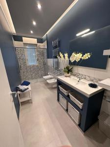 a bathroom with two sinks and a large mirror at Faro Sul Mare Luxury Apartment - Zona Fiera in Bari