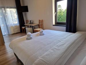 a bedroom with a large white bed with a window at Casa 7 SATE apartament in Săcele