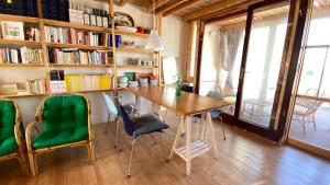a dining room with a wooden table and green chairs at San Liberale sul mare in Trapani