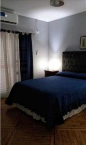 um quarto com uma cama com um cobertor azul em Nono Angelo Primero em San Pedro