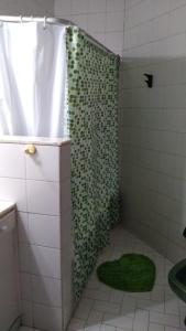 uma casa de banho com um chuveiro com uma cortina de chuveiro verde em Nono Angelo Primero em San Pedro