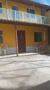 a yellow house with a porch and a balcony at Casa de Praia / Cabo Frio in Tamoios