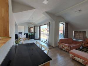 a living room with a couch and a table in it at Apartman Gradina in Doboj +2 photos