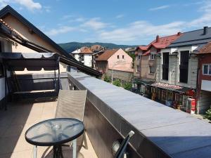 a balcony with a table and chair on a building at Apartman Gradina in Doboj