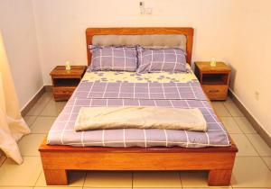 a bed in a bedroom with two night stands at LES LOGIS DE NOUVELLE ROUTE BASTOS in Yaoundé