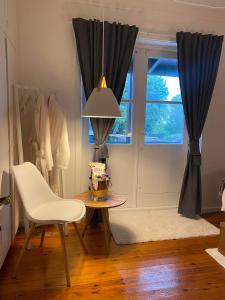 a dining room with a table and a chair and a window at Unik BnB midt i byen - mad event og bilopladning in Herning