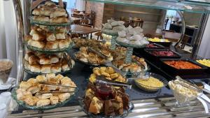a buffet with many different types of bread and pastries at Ville Celestine Condo Hotel e Eventos in Belo Horizonte