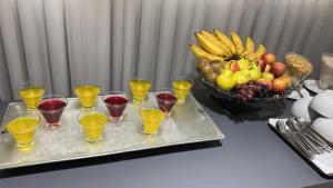 a tray of wine glasses and a bowl of fruit at Ville Celestine Condo Hotel e Eventos in Belo Horizonte