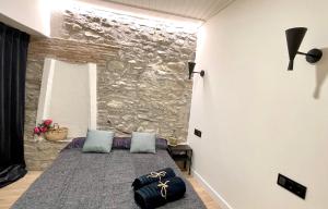 1 dormitorio con 1 cama con pared de piedra en Apartamento colgante al río con vistas al puente, en Camprodon
