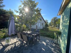 eine Terrasse mit einem Tisch, Stühlen und einem Sonnenschirm in der Unterkunft Ferienhaus Seekoje in Neustadt-Glewe