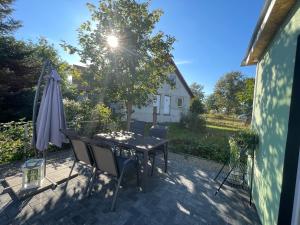 een patio met een tafel en stoelen en een parasol bij Ferienhaus Seekoje in Neustadt-Glewe