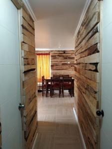 a room with a wooden wall and a dining room at S&J Casa Cabaña in El Tabo