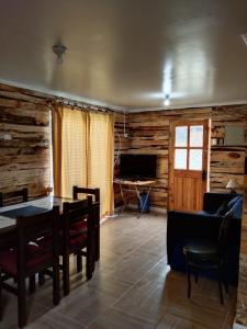 a living room with a table and a couch and a television at S&J Casa Cabaña in El Tabo