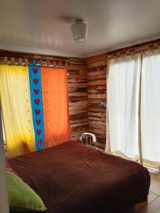 a bedroom with colorful curtains and a bed at S&J Casa Cabaña in El Tabo
