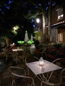 een patio met tafels en stoelen in de nacht bij Corredoura Garden in Caldelas
