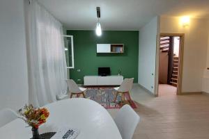 a room with a table and chairs and a green wall at Dimora Mirtilla - alloggio, max 4 posti letto. in Petacciato