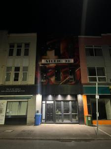 un bâtiment avec un panneau à l'avant de celui-ci la nuit dans l'établissement OYO The Studio, à Swansea