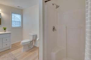 a white bathroom with a toilet and a shower at Idyllic Cave Spring Studio with Patio and Fire Pit! in Cave Spring