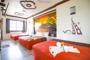 una camera d'albergo con due letti e un dipinto sul muro di Hotel Diamante a Santa Cruz Huatulco