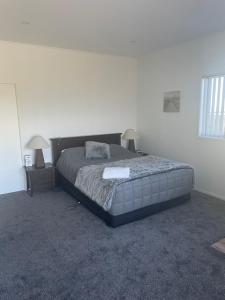 a bedroom with a bed and two nightstands and two lamps at Wander Inn in Kaitaia