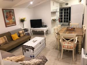 a living room with a couch and a table at Gîte des Tournesols in Oradour-Fanais