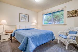 a bedroom with a bed and two chairs and a window at Sandpiper Retreat in Waldport