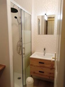uma casa de banho com um lavatório e um chuveiro com um espelho. em Résidence cap océan, Port du Crouesty em Arzon