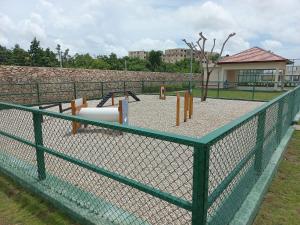 una valla de cadena con equipo de juegos en un parque en Pool Breeze 202 en Punta Cana