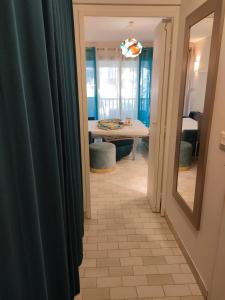 einen Flur mit blauen Vorhängen und einem Tisch in einem Zimmer in der Unterkunft Au petit bonheur in Sanary-sur-Mer