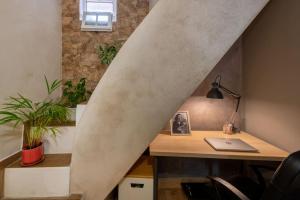 - un bureau sous les escaliers avec un bureau et un ordinateur portable dans l'établissement Casa Cecilia Apartment Algarve, à Alte