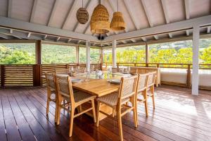 a dining room with a wooden table and chairs at Villa Vi - St Barth in Saint Barthelemy