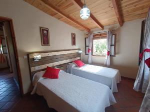 a bedroom with two beds and a window at La Encina Casa Rural 