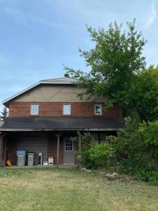 a brick house with a tree in front of it at ENTIRE 2-BEDROOM TOWNHOUSE ON a RUSTIC FARM - C in Arkona