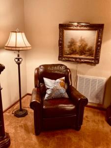 silla de cuero marrón con almohada y lámpara en Sundance Suite - Prairie Rose B&B en Cheyenne