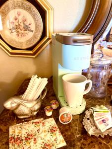 Sundance Suite - Prairie Rose B&B في شايان: طاولة مع آلة صنع القهوة وكوب من القهوة