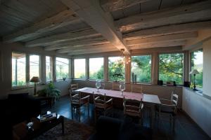 comedor con mesa, sillas y ventanas en La Villa Montillet, en Cluny