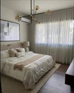 een slaapkamer met een groot bed en een groot raam bij Villa in zamzam city 